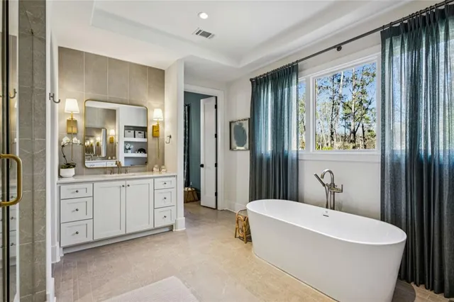 a bathroom with a bathtub a sink and a large mirror