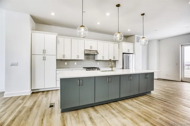 a large kitchen with kitchen island white cabinets and wooden floor