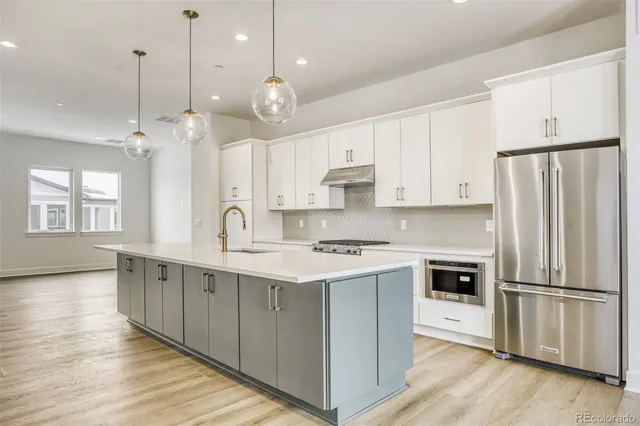 a kitchen with kitchen island white cabinets and stainless steel appliances
