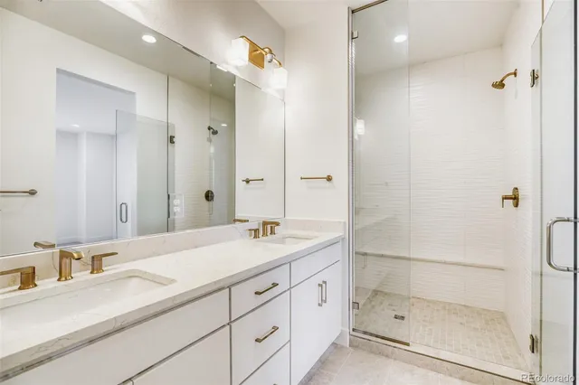a bathroom with a shower sink vanity granite and mirror