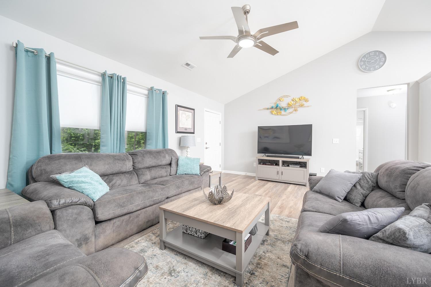 905 Gap Bridge Road Moneta, VA 24121 - Photo 12 of 48 a living room with furniture a large window and a flat screen tv