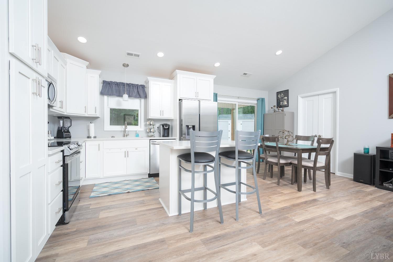 905 Gap Bridge Road Moneta, VA 24121 - Photo 13 of 48 a kitchen with stainless steel appliances kitchen island granite countertop a table chairs sink and cabinets