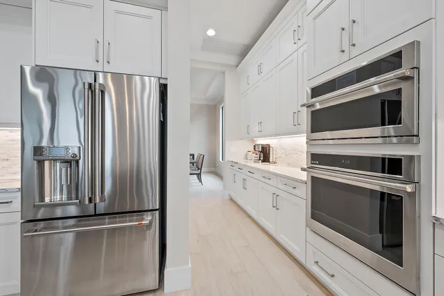 a kitchen with stainless steel appliances white cabinets and a refrigerator