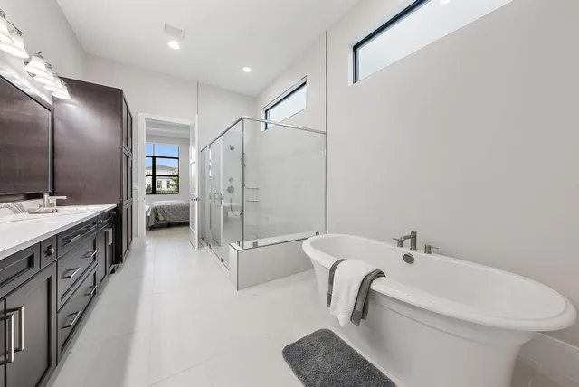 a bathroom with a double vanity sink a toilet a mirror and shower