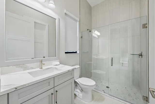 a bathroom with a sink a toilet and shower