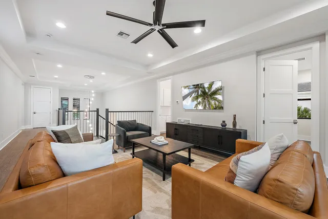 a living room with furniture and a ceiling fan