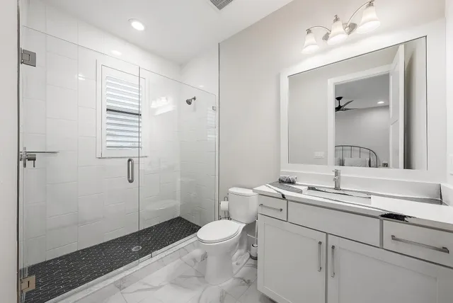 a bathroom with a sink a toilet and shower