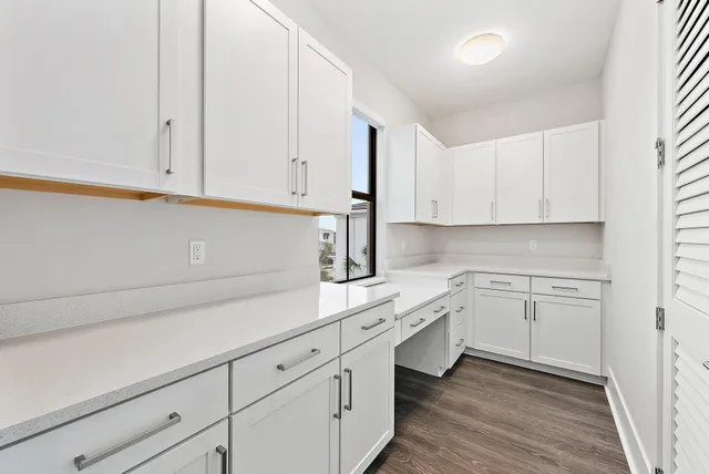 a kitchen with white cabinets and sink