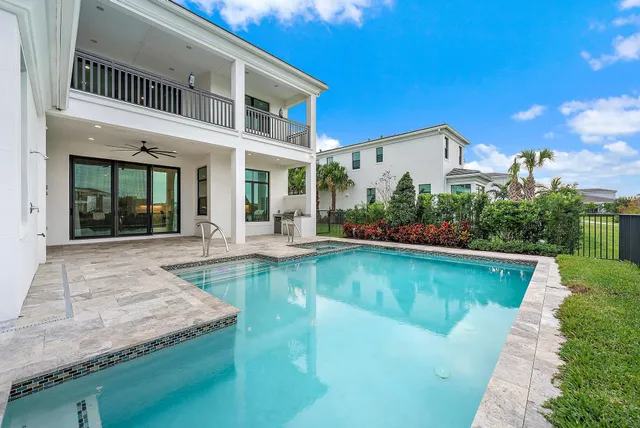 a view of a house with swimming pool and sitting area
