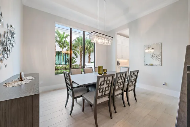 a dining room with furniture a chandelier and wooden floor