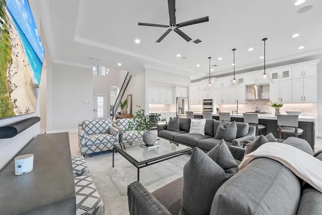 a living room with furniture kitchen view and a window