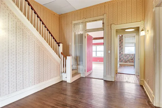 a view of a hallway with wooden floor and windows