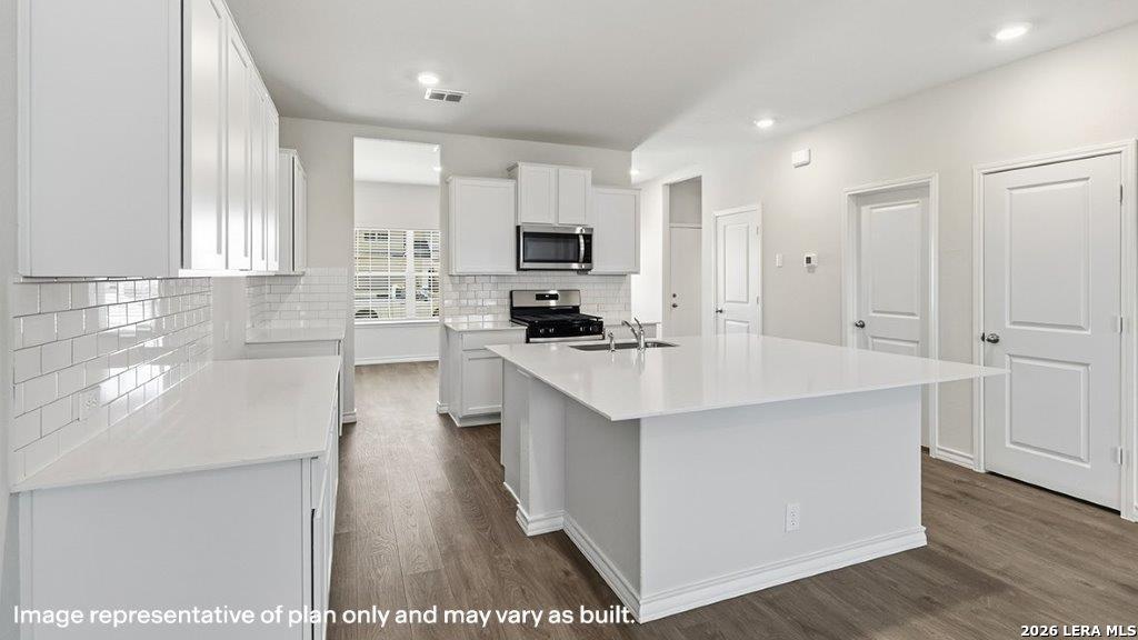 620 Fluted Shoals Cibolo, TX 78108 - Photo 8 of 44 a kitchen with kitchen island white cabinets and stainless steel appliances