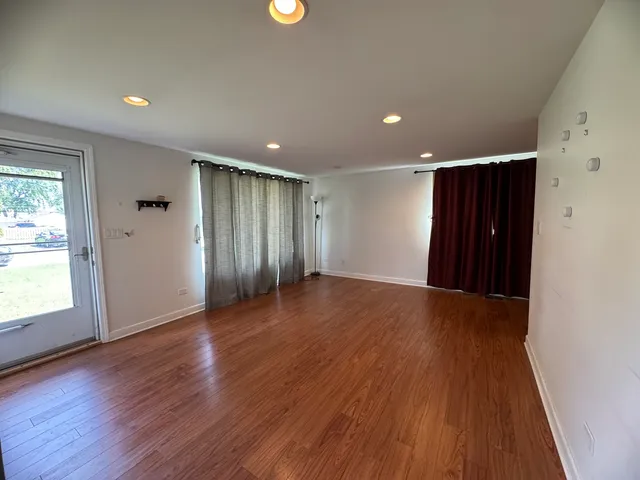 a view of an empty room with wooden floor