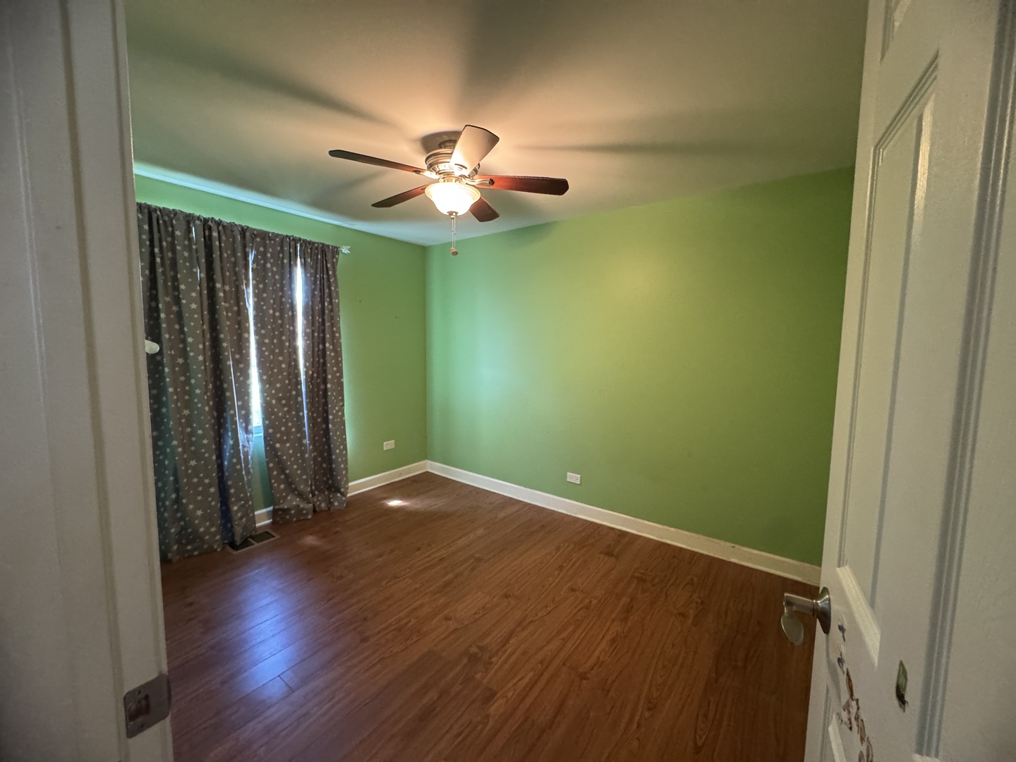 4049 West 89th Place Hometown, IL 60456 - Photo 9 of 11 an empty room with wooden floor fan and windows