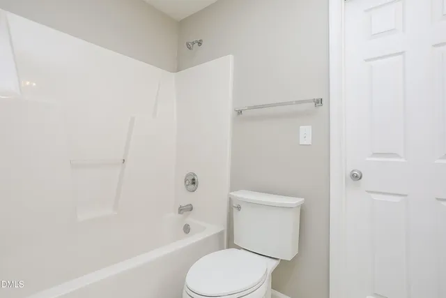 a white toilet sitting next to a bath tub