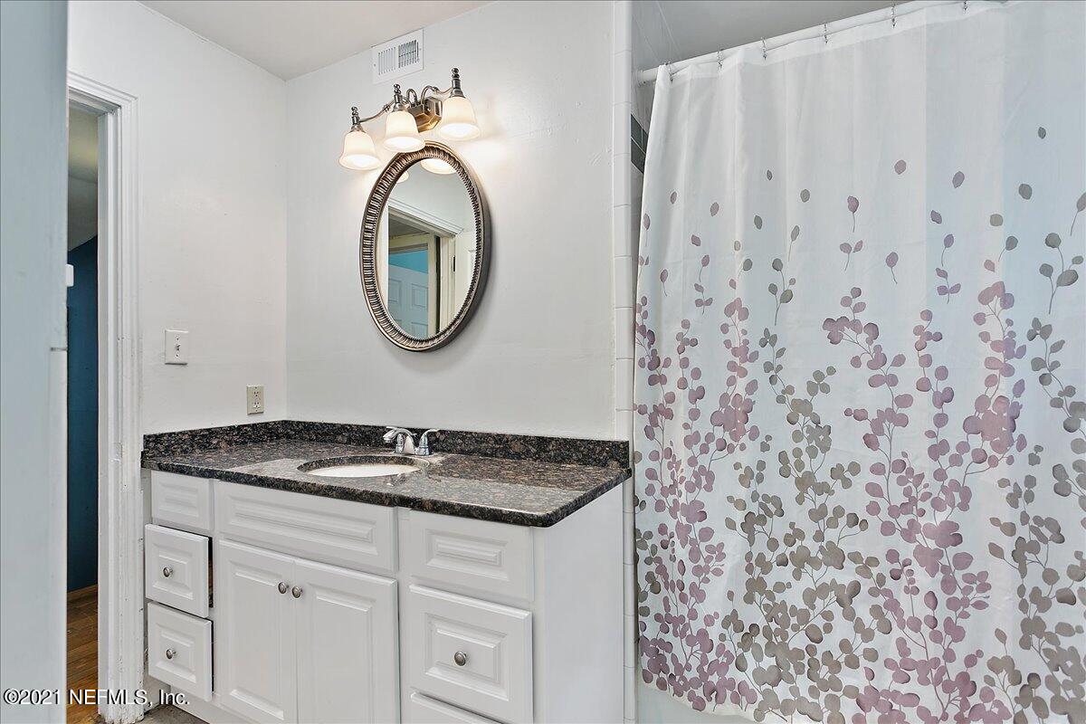 2040 Broward Road Jacksonville, FL 32218 - Photo 17 of 22 a bathroom with a granite countertop sink and a mirror