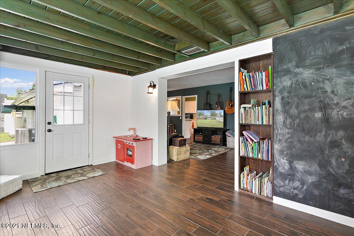 2040 Broward Road Jacksonville, FL 32218 - Photo 6 of 22 a hallway with wooden floor and book shelf