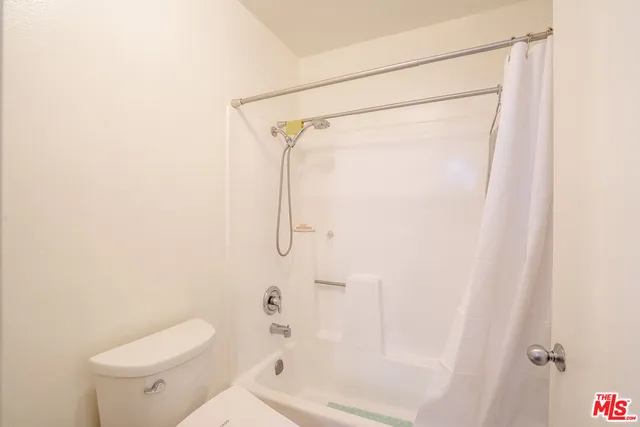 a bathroom with a shower a toilet and a shower