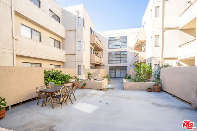 a building outdoor space with patio furniture and potted plants