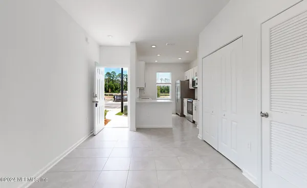 a view of a hallway with wooden floor and a kitchen