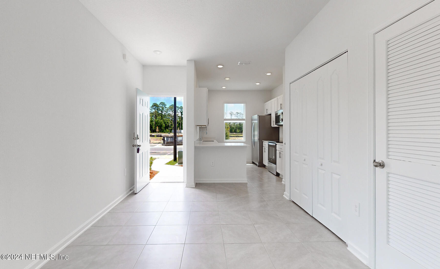 97 Hidden Mdws Road St. Augustine, FL 32095 - Photo 7 of 27 a view of a hallway with wooden floor and a kitchen