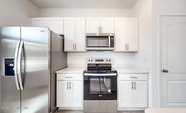 a kitchen with cabinets stainless steel appliances and a counter space