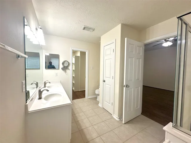 a bathroom with a tub a sink double vanity and a mirror