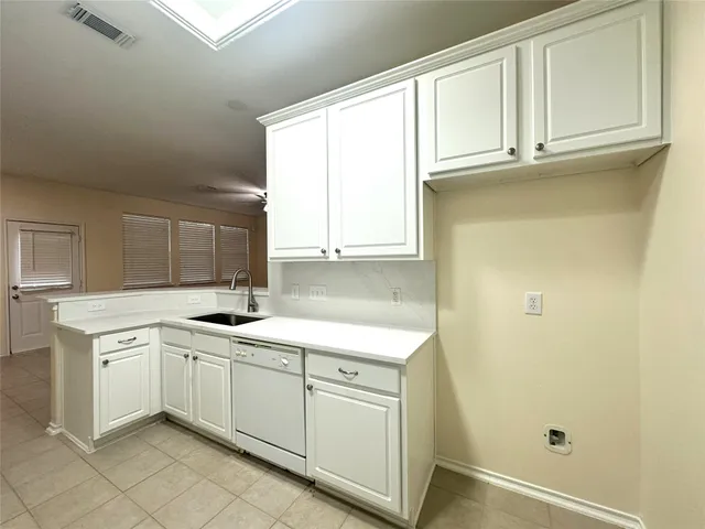 a kitchen with white cabinets and white appliances