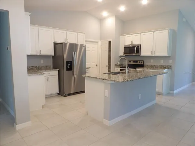 a kitchen with a refrigerator sink and cabinets