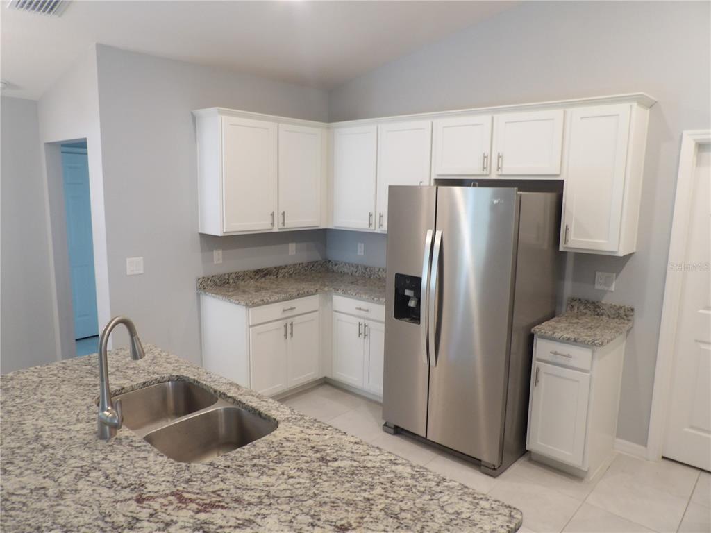 7653 Minardi Street North Port, FL 34291 - Photo 8 of 20 a kitchen with stainless steel appliances granite countertop a refrigerator sink and cabinets