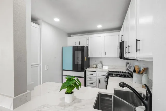 a kitchen with stainless steel appliances kitchen island granite countertop a refrigerator and a stove top oven