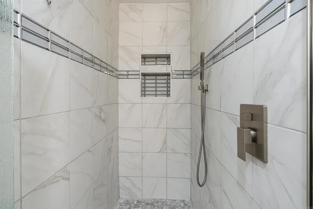 a bathroom with a shower and a glass door