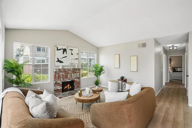 a living room with furniture fireplace and potted plants