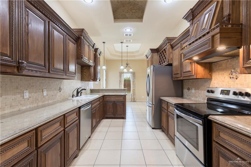 4212 Toronto Avenue McAllen, TX 78503 - Photo 4 of 15 a kitchen with stainless steel appliances granite countertop a sink a stove and cabinets