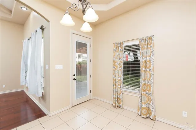 a view of a hallway with wooden floor and chandelier