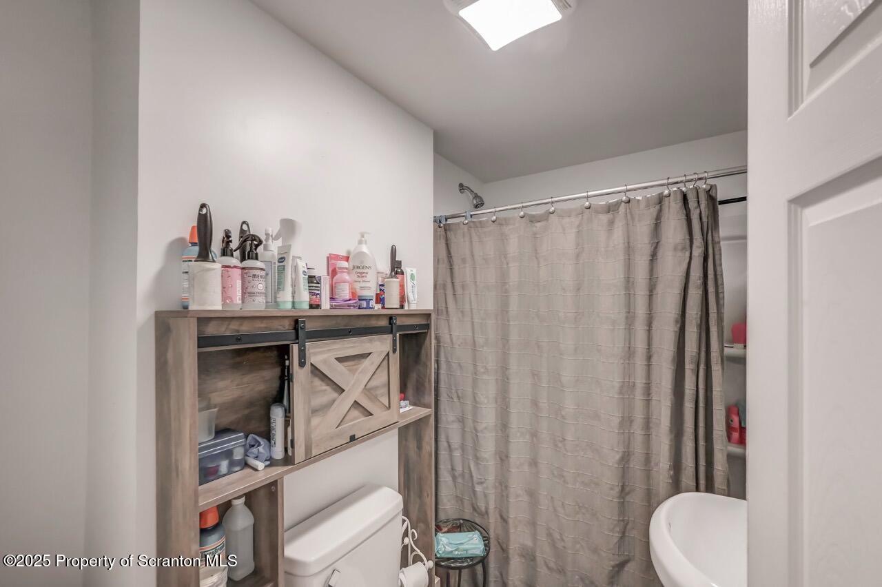 317-319 10th Avenue Scranton, PA 18504 - Photo 20 of 64 a bathroom with a sink a toilet and shower curtain