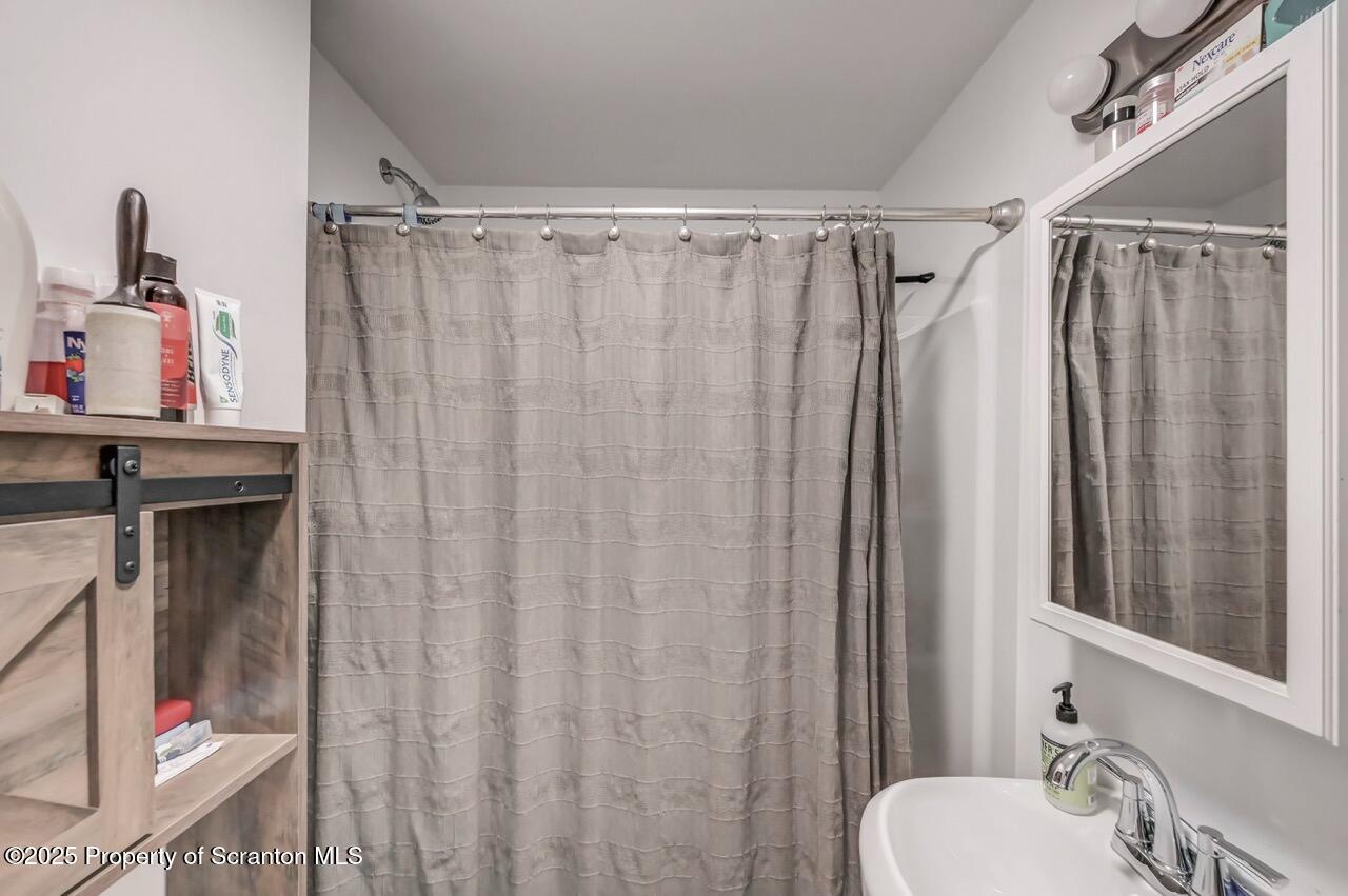 317-319 10th Avenue Scranton, PA 18504 - Photo 21 of 64 a bathroom with a shower curtain and a sink
