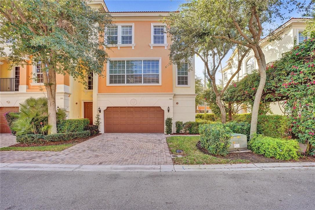5565 Northeast Trieste Way, Unit 5565 Boca Raton, FL 33487 - Photo 1 of 44 a front view of a house with a yard and a garage