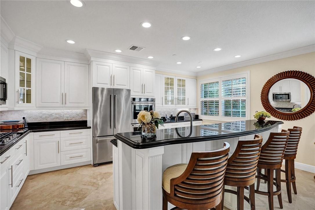 5565 Northeast Trieste Way, Unit 5565 Boca Raton, FL 33487 - Photo 16 of 44 a kitchen with granite countertop a sink a counter space appliances and cabinets