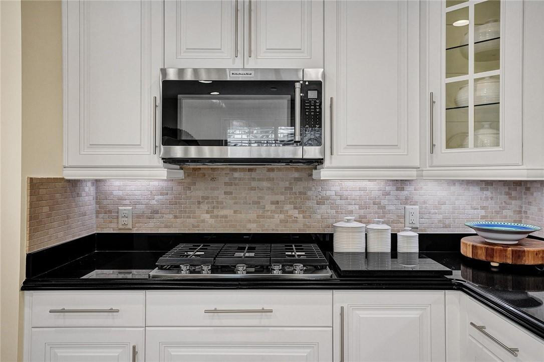 5565 Northeast Trieste Way, Unit 5565 Boca Raton, FL 33487 - Photo 20 of 44 a kitchen with a stove and white cabinets