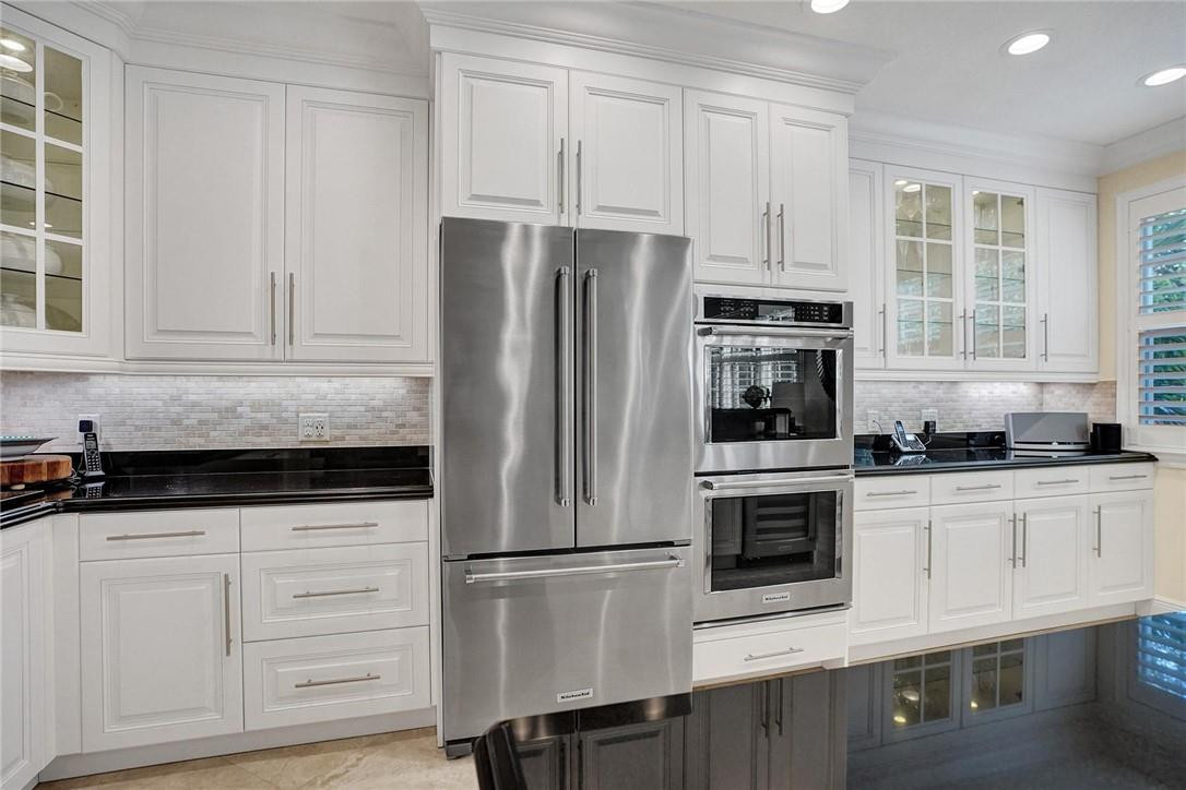 5565 Northeast Trieste Way, Unit 5565 Boca Raton, FL 33487 - Photo 2 of 44 a kitchen with granite countertop white cabinets and stainless steel appliances