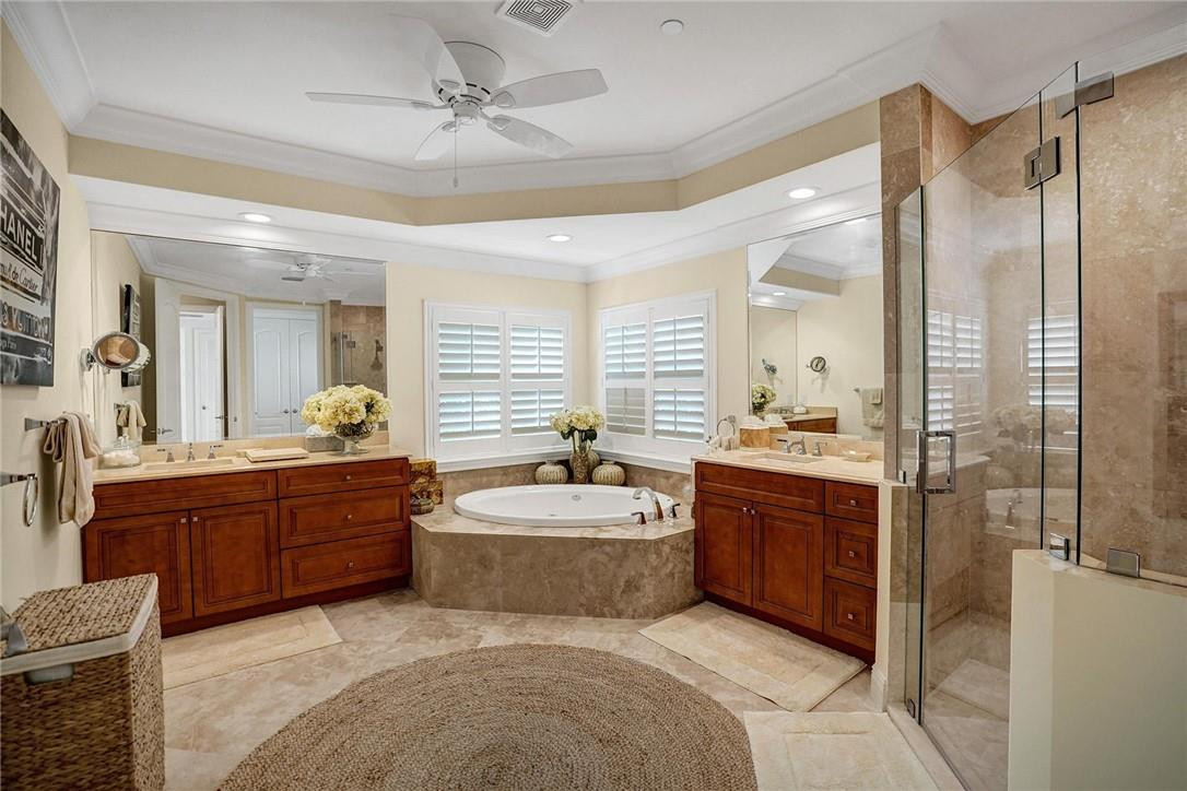 5565 Northeast Trieste Way, Unit 5565 Boca Raton, FL 33487 - Photo 25 of 44 a bathroom with a tub sink shower and mirror