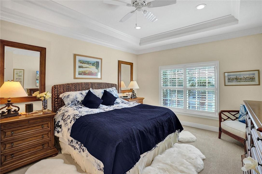 5565 Northeast Trieste Way, Unit 5565 Boca Raton, FL 33487 - Photo 27 of 44 a spacious bedroom with a bed a couch and dresser