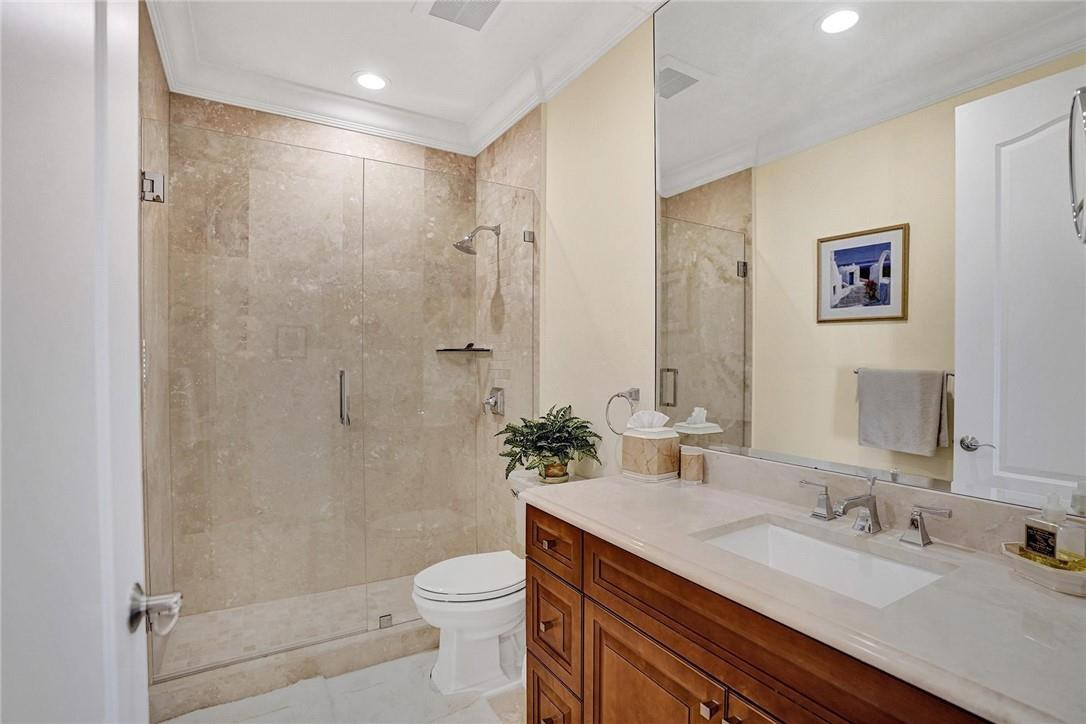 5565 Northeast Trieste Way, Unit 5565 Boca Raton, FL 33487 - Photo 32 of 44 a bathroom with a granite countertop sink a toilet a shower and a mirror