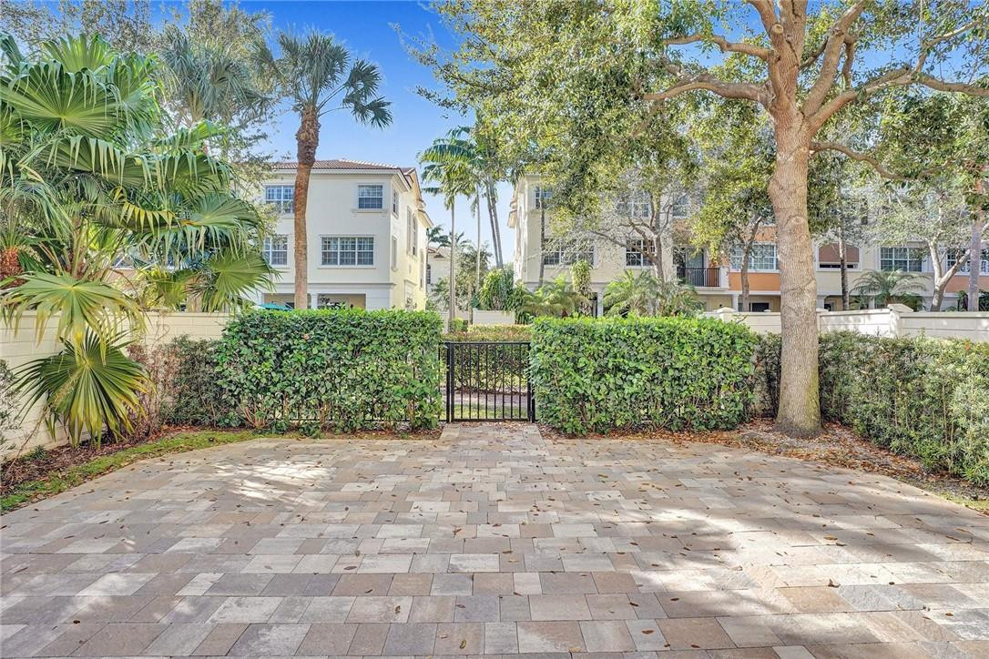 5565 Northeast Trieste Way, Unit 5565 Boca Raton, FL 33487 - Photo 33 of 44 a view of a garden with potted plants and large trees