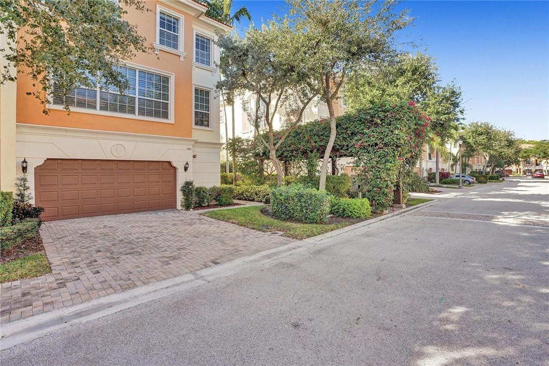 5565 Northeast Trieste Way, Unit 5565 Boca Raton, FL 33487 - Photo 38 of 44 a front view of a house with a yard and garage