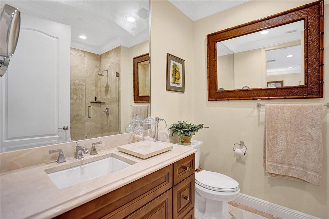 5565 Northeast Trieste Way, Unit 5565 Boca Raton, FL 33487 - Photo 9 of 44 a bathroom with a toilet a sink and mirror