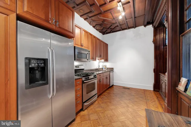 a kitchen with stainless steel appliances granite countertop a refrigerator and a stove