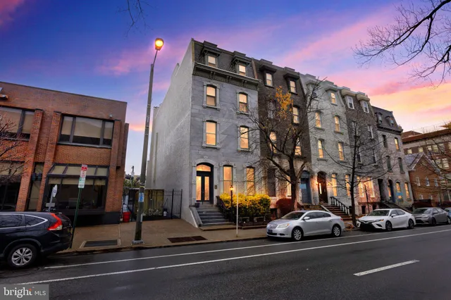 a view of a building and car parked on the street